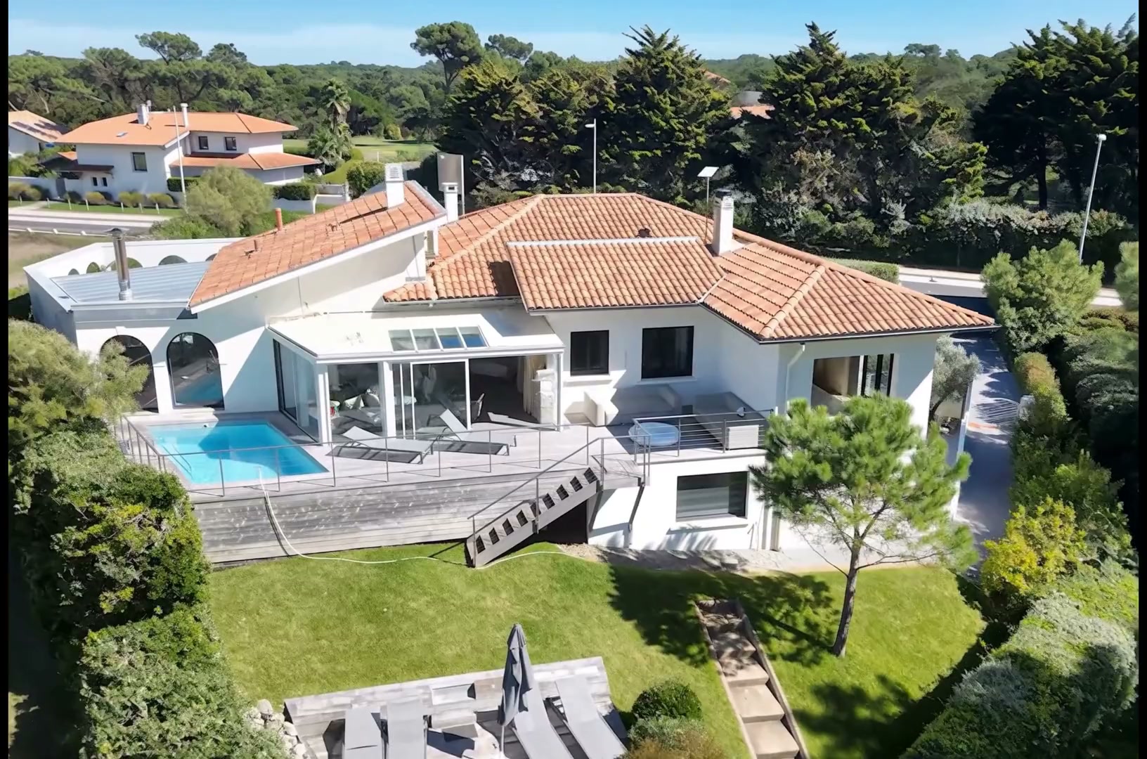 Plan extrait d'un film ImmersiFly : façade d'une maison contemporaine survolée au lever du jour